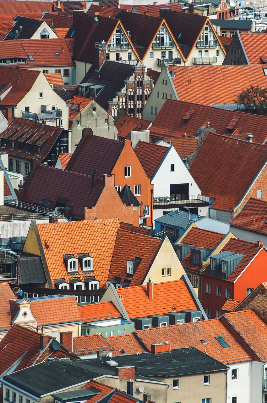 Colourful houses with red tiled roofs representing neighbourhoods and communities who benefit from NFS Mediation's services.