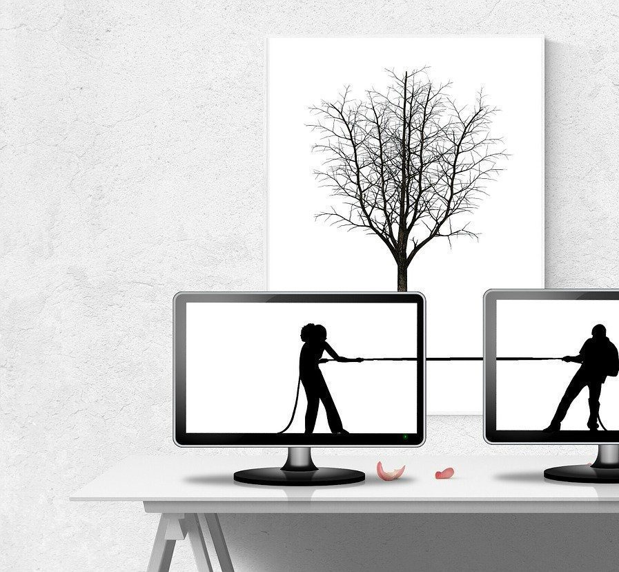 Online conflict resolution illustrated by two people in a virtual tug-of-war on computer screens.